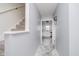 Hallway featuring a staircase, light gray walls, modern tile floors, and a view into the bright kitchen at 5236 Honey Comb Ln, Indianapolis, IN 46221