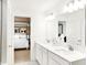 Bathroom with double vanity, large mirror, quartz countertop, and doorway into the bedroom at 5312 Summerton St, McCordsville, IN 46055