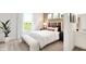 A bright bedroom features a cozy bed with a decorative headboard and a pleasant view of the lawn at 5312 Summerton St, McCordsville, IN 46055