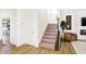 Inviting entryway featuring a carpeted staircase, light wood floors, and a neutral color palette at 5312 Summerton St, McCordsville, IN 46055