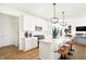Modern kitchen with a spacious island, white cabinetry, and pendant lighting overlooking the living area at 5312 Summerton St, McCordsville, IN 46055