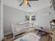 Bright Bedroom with wood floor, white crib, chair, and a corner window at 547 W Taylor St, Shelbyville, IN 46176