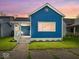 Charming blue two-story home with a quaint front porch and well-maintained lawn at dusk at 547 W Taylor St, Shelbyville, IN 46176