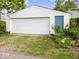 Exterior shot of garage with white door, blue side door, and lawn at 547 W Taylor St, Shelbyville, IN 46176