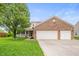 Charming two-story home with a well-manicured lawn and attached two-car garage at 6026 Pennyworth Cir, Indianapolis, IN 46203