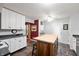 Cozy kitchen featuring white cabinets, an island with wooden accents, and a modern ceiling fan at 6026 Pennyworth Cir, Indianapolis, IN 46203