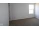 Bright bedroom features neutral carpet, base trim, and a large window at 6223 Medina Spirit Dr, Indianapolis, IN 46237