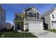 Charming two-story home with gray siding, black shutters, and a spacious two-car garage at 6223 Medina Spirit Dr, Indianapolis, IN 46237