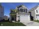 Two story home features a two car garage, grey siding, black shutters, and manicured lawn at 6223 Medina Spirit Dr, Indianapolis, IN 46237