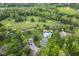 Aerial view of a community with a golf course, swimming pool, tennis courts, and lush greenery at 6230 E 56Th St, Indianapolis, IN 46226