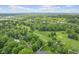 Beautiful aerial view of lush golf course, lake, and wooded neighborhood with single Gathering homes under a partly cloudy sky at 6230 E 56Th St, Indianapolis, IN 46226