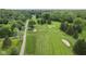 Overhead view of beautiful golf course with verdant fairways and sand traps surrounded by lush trees under a blue sky at 6230 E 56Th St, Indianapolis, IN 46226