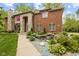 Elegant brick home with stone accents, a well-manicured garden, and a charming water feature at 6230 E 56Th St, Indianapolis, IN 46226