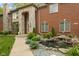 Close-up of the brick facade home with stone accents, garden pond, and manicured landscape at 6230 E 56Th St, Indianapolis, IN 46226