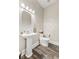 Cozy powder room with hardwood flooring, pedestal sink, and contemporary lighting at 6230 E 56Th St, Indianapolis, IN 46226
