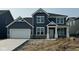 Two-story home featuring blue siding, white trim, and a two-car garage at 6551 Ambassador Dr, Plainfield, IN 46168