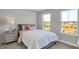 Light-filled bedroom with plush bedding, a nightstand, and two windows overlooking a construction site at 6683 Halsey St, Zionsville, IN 46077