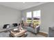 Bright living room with a gray sofa, patterned pillows, unique coffee table, and large windows for natural light at 6683 Halsey St, Zionsville, IN 46077
