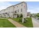View of the exterior of a tan townhouse with a walkway and green grass at 6916 Havenmoor Pl, Indianapolis, IN 46250