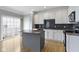 Kitchen features white cabinets, stainless steel appliances, a granite island, and a sliding door to the balcony at 6916 Havenmoor Pl, Indianapolis, IN 46250