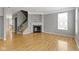 Bright living area features a fireplace with mantel, a large window, and hardwood flooring at 6916 Havenmoor Pl, Indianapolis, IN 46250