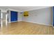 Spacious living room featuring gray walls, wood floors, and a brightly painted accent wall at 6916 Havenmoor Pl, Indianapolis, IN 46250