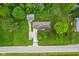 Aerial view of a home with lush green lawn, detached garage, driveway, trees and a road nearby at 6925 W State Road 128, Frankton, IN 46044