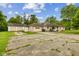 Home exterior featuring a detached garage and a cracked concrete driveway at 6925 W State Road 128, Frankton, IN 46044