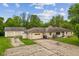 Home with stone facade, attached garage, detached garage, and a cracked concrete driveway at 6925 W State Road 128, Frankton, IN 46044