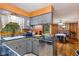 Open kitchen with stainless steel appliances, custom cabinets, and a breakfast bar open to the dining room at 6925 W State Road 128, Frankton, IN 46044
