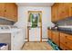 Functional laundry room with washer, dryer, ample cabinet space, and a convenient exterior door at 6925 W State Road 128, Frankton, IN 46044