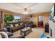 Comfortable living room featuring leather furniture, ceiling fan, stone fireplace, and large window at 6925 W State Road 128, Frankton, IN 46044
