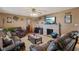 Living room featuring leather furniture, ceiling fan, stone fireplace, and beige walls at 6925 W State Road 128, Frankton, IN 46044