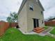 Exterior backyard view featuring a fenced lawn, a small patio and side door entrance at 704 E Perry St, Indianapolis, IN 46227
