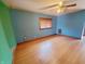 Spacious bedroom with blue walls, wood-look floors, and a window with wood-colored blinds at 704 E Perry St, Indianapolis, IN 46227