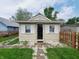 The home's quaint front entrance with a dark door and white trim and shutters creates a welcoming ambiance at 704 E Perry St, Indianapolis, IN 46227