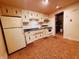 Compact kitchen boasts cream cabinets, white appliances, and a dark countertop at 704 E Perry St, Indianapolis, IN 46227
