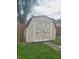 Backyard shot featuring a barn-style storage shed with double doors and grass lawn at 704 E Perry St, Indianapolis, IN 46227