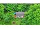 Aerial view of a house surrounded by lush green trees, highlighting the backyard and a deck at 7335 Bethany Park, Martinsville, IN 46151