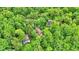 An aerial view shows a home with a blue tarp surrounded by lush trees at 7335 Bethany Park, Martinsville, IN 46151