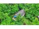 Aerial view of a house surrounded by lush green trees, showcasing a deck with a blue canopy at 7335 Bethany Park, Martinsville, IN 46151