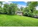 Expansive backyard with lush green grass, mature trees, and a deck with a blue canopy at 7335 Bethany Park, Martinsville, IN 46151