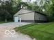 Large metal barn featuring tan and brown siding, a gravel driveway, and surrounded by lush greenery at 7335 Bethany Park, Martinsville, IN 46151