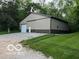Spacious metal barn featuring a large garage door, set amidst lush greenery at 7335 Bethany Park, Martinsville, IN 46151