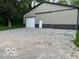 A sturdy metal barn with a garage door and gravel driveway surrounded by green landscape at 7335 Bethany Park, Martinsville, IN 46151