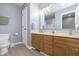 Bathroom featuring double sink vanity, wood cabinets, gray paint, and a white door at 7430 Franklin Parke Woods, Indianapolis, IN 46259