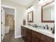 Well-lit bathroom with double sink vanity, granite countertops, and wood-look ceramic tile floors at 7430 Franklin Parke Woods, Indianapolis, IN 46259