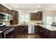 Modern kitchen boasts dark wood cabinets, granite counters, and stainless steel appliances, with an open design at 7430 Franklin Parke Woods, Indianapolis, IN 46259