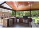 Outdoor kitchen and bar with stainless grill under wooden patio cover at 7430 Franklin Parke Woods, Indianapolis, IN 46259