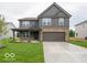 Two-story home with gray siding, stone accents, covered porch, and two-car garage at 7517 Big Bend Blvd, Camby, IN 46113